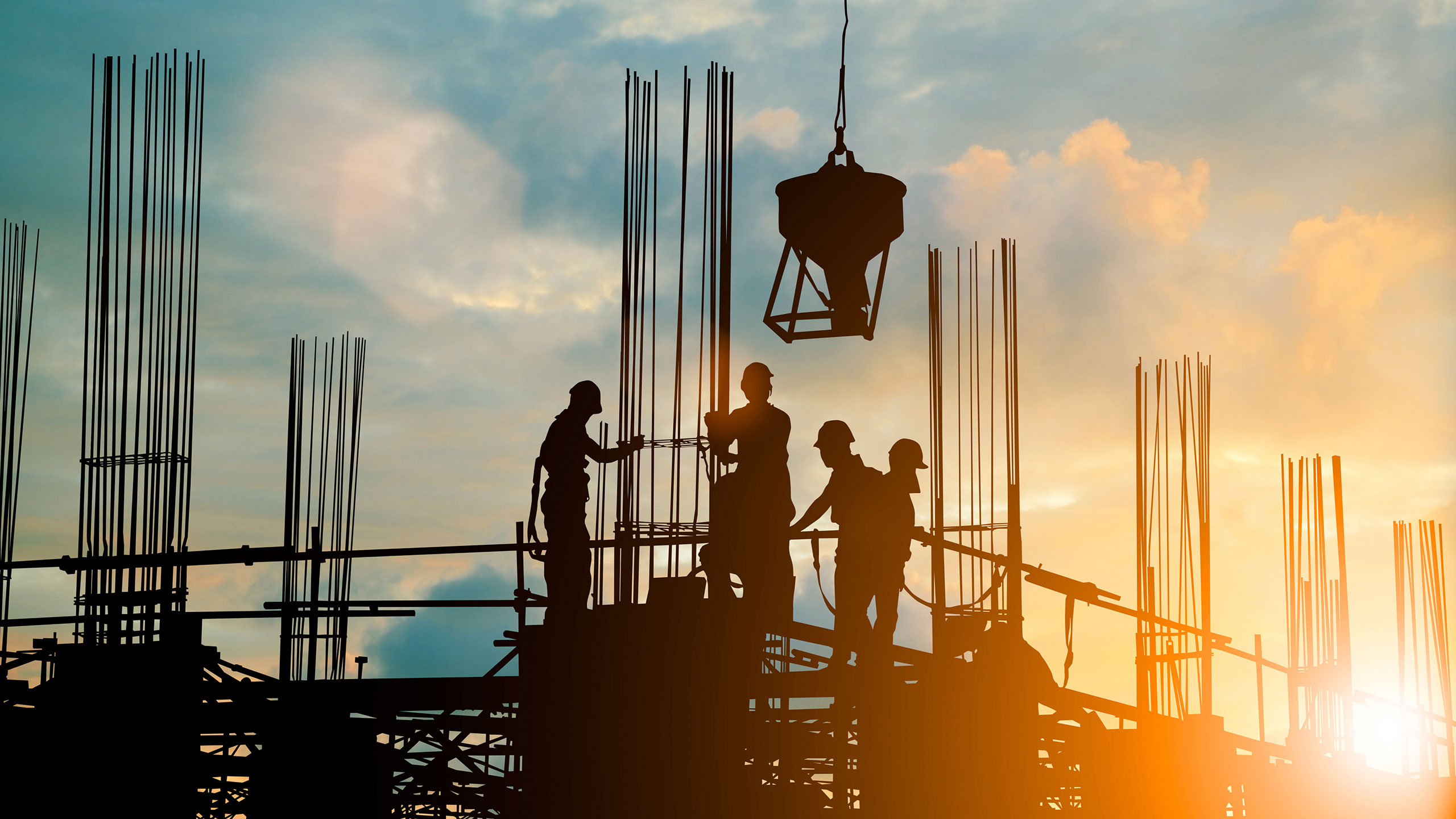 Construction workers at sunset